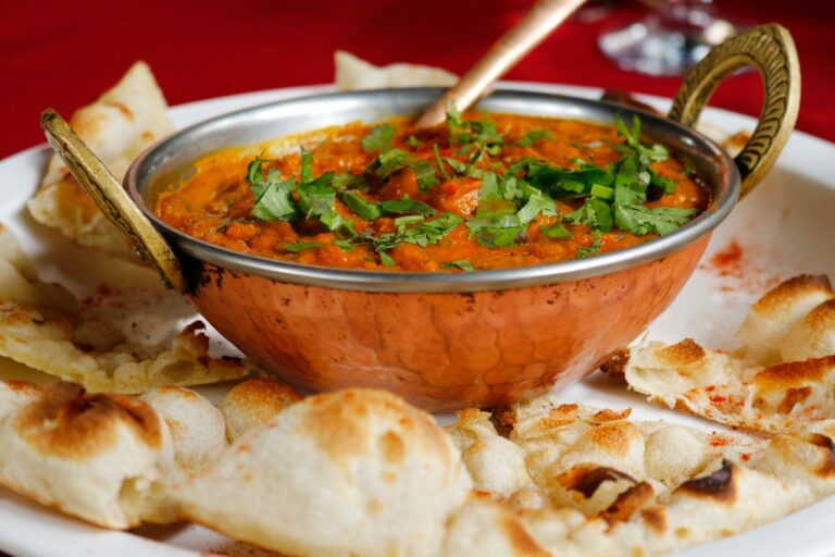A delicious bowl of curry and bread on a plate, served by a tiffin service near me. Enjoy a flavorful meal!